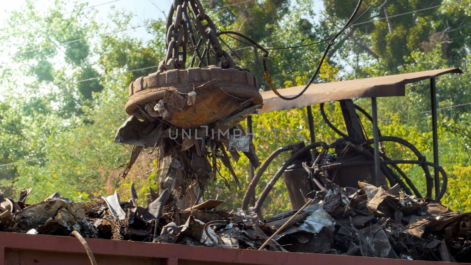 Photo of metal scrap and waste stcking to the electric magnet on dump