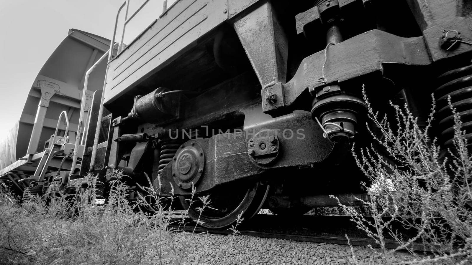 Black and white photoof big cargo train cars on industrial railroad