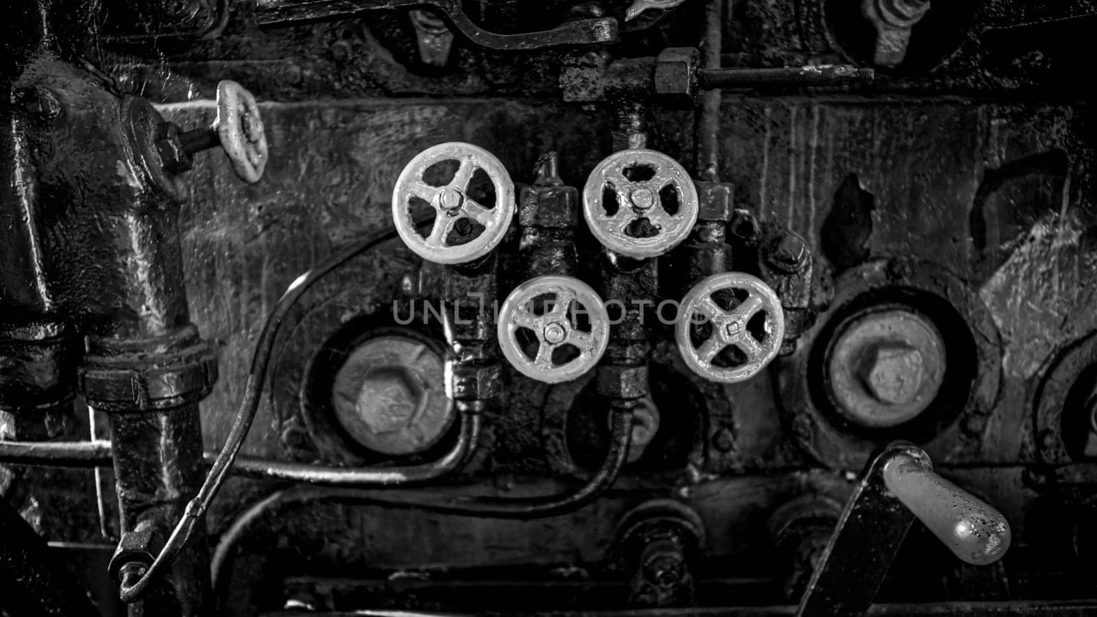 Black and white image of valves and faucets on old steam powered train engine
