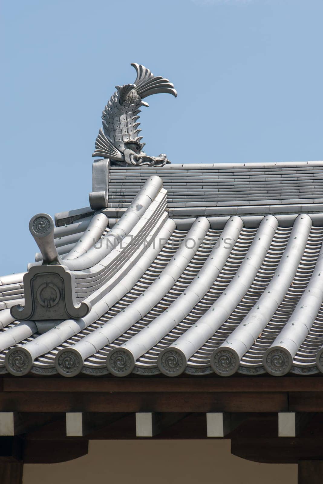 Japanese temple roof tiles against blue sky