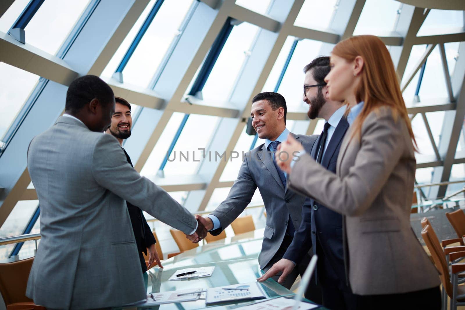 Business partners handshaking upon striking deal in office
