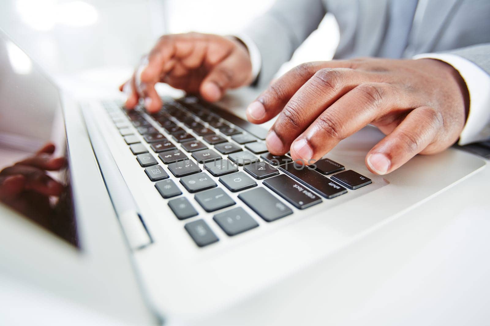 Hands of African businessman typing