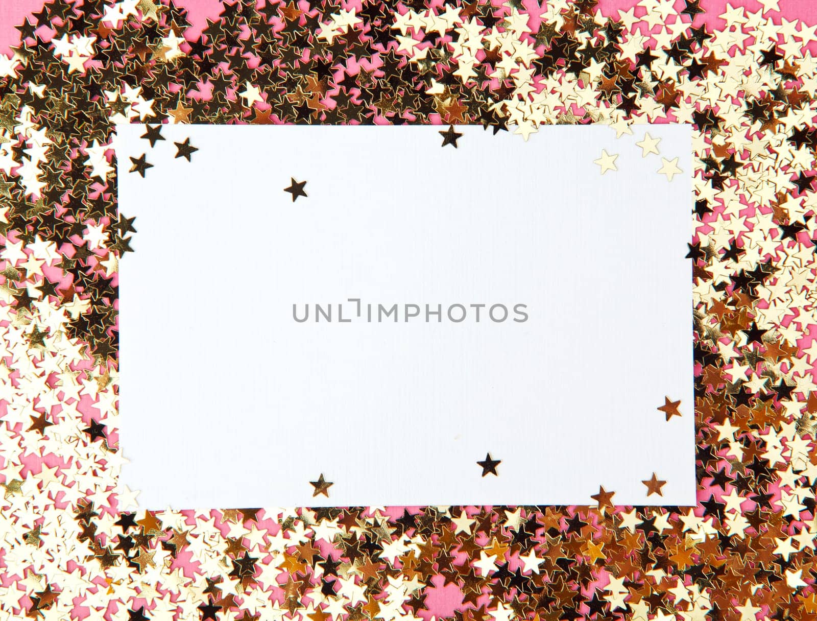 frame made of decorative stars with clean shit of paper on pink background
