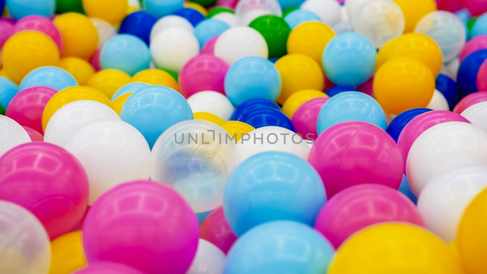 Closeup abstract photo of colorful plastic ball in pit on the playground at shopping mall.