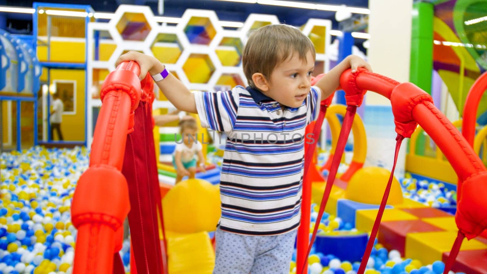 Portrait of cute little boy balancing on balancing board in children playroom at shopping mall.