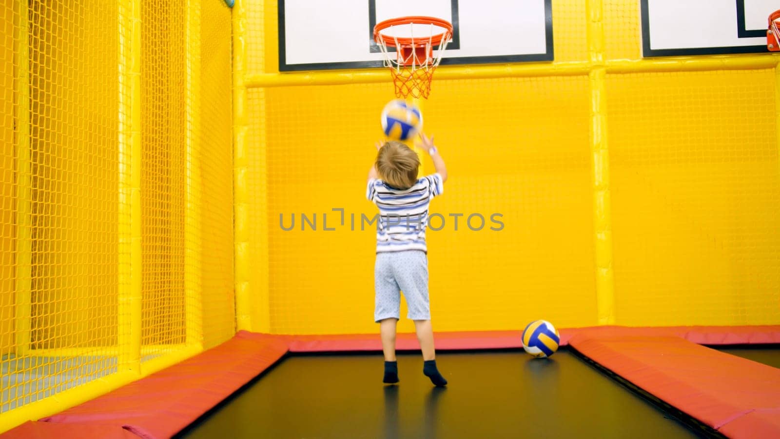 Cute little boy playing in basketball on playground at amusement park.
