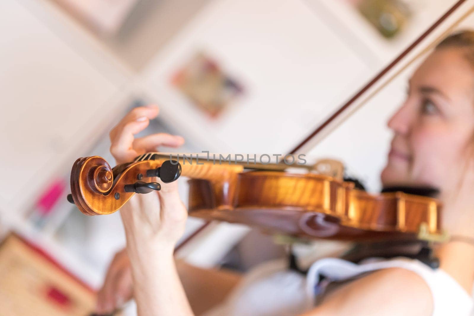 Pretty young girl practices on her violin, acoustic music