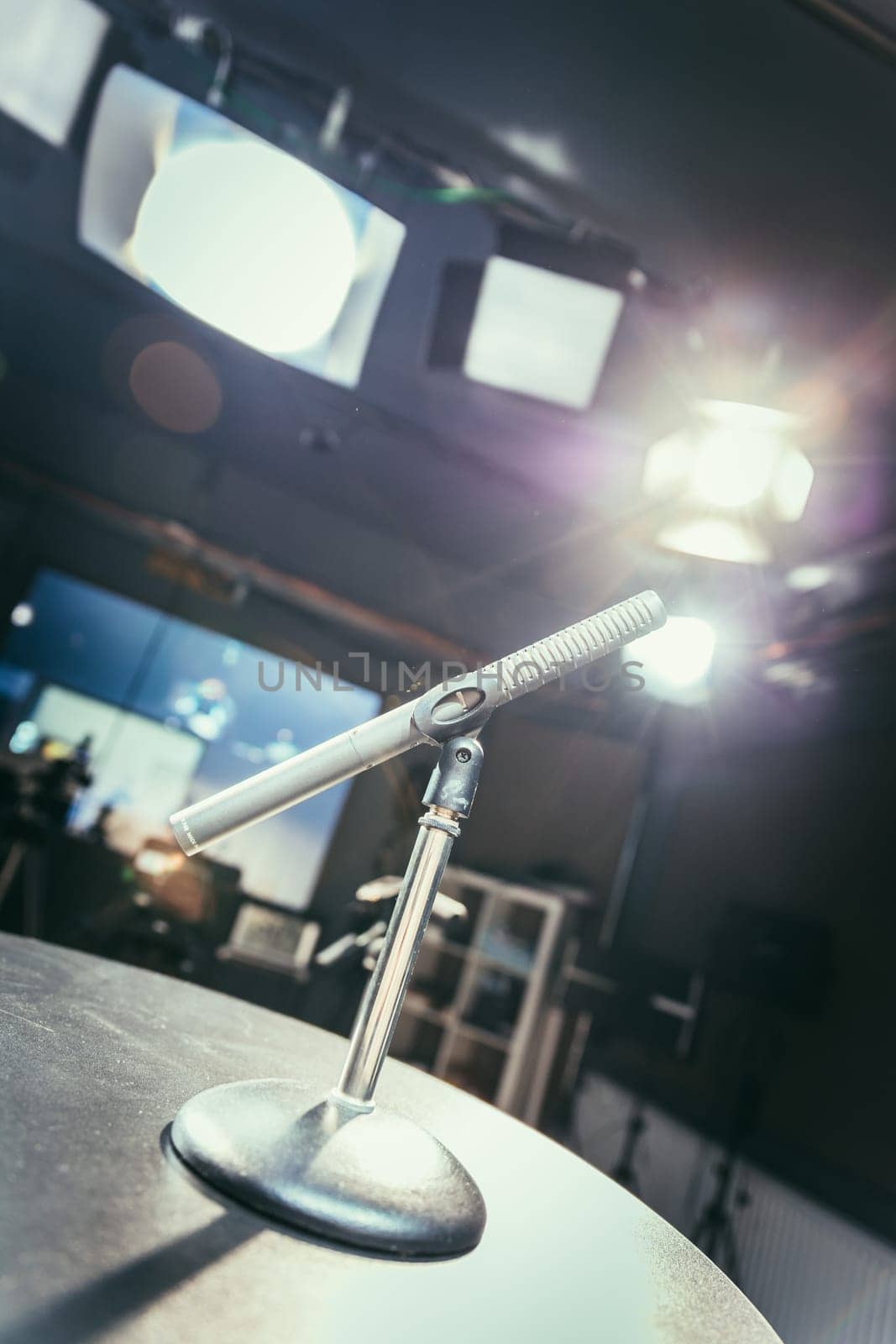 Metal microphone in the studio, studio lights in the blurry background