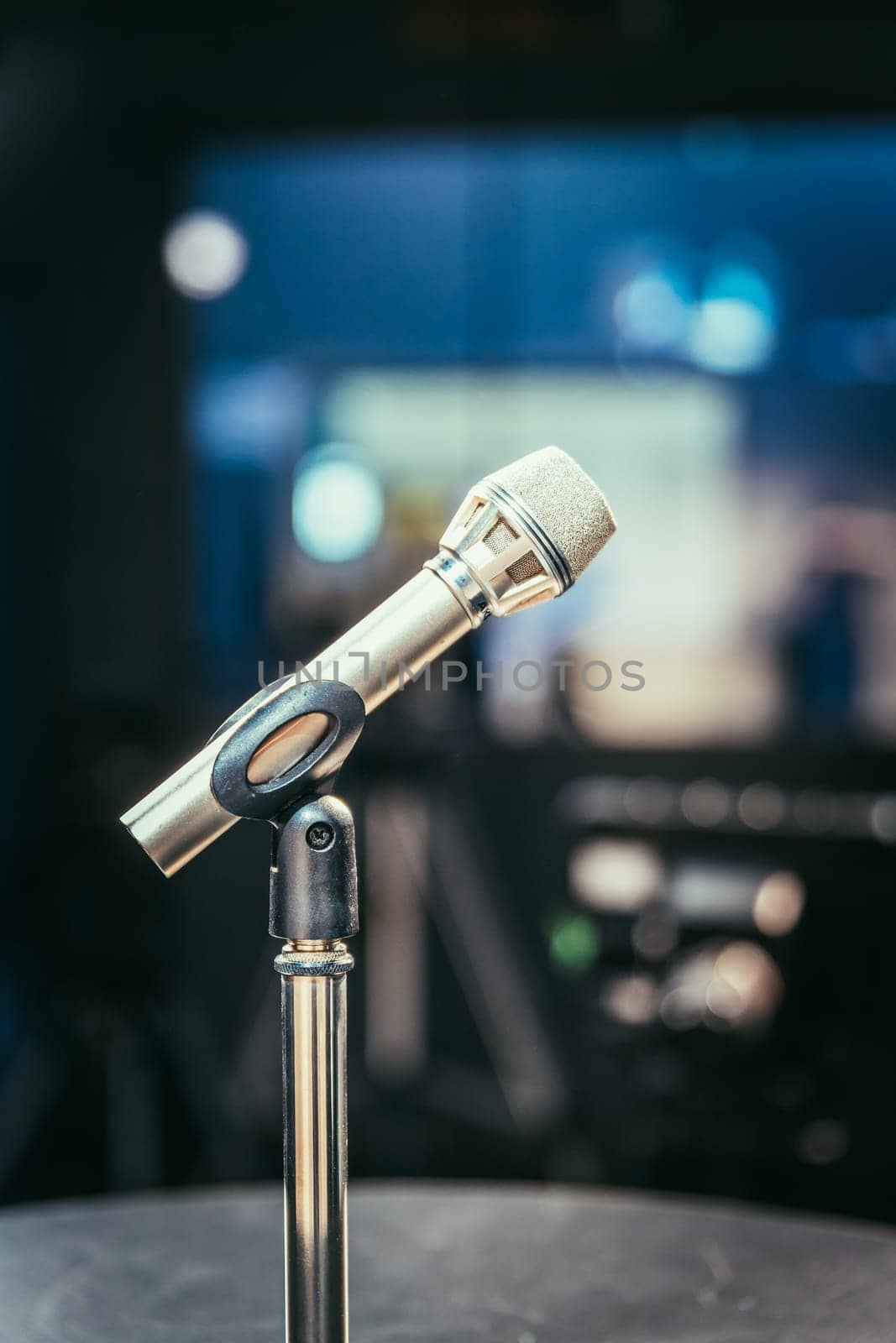 Metal microphone in the studio, studio lights in the blurry background