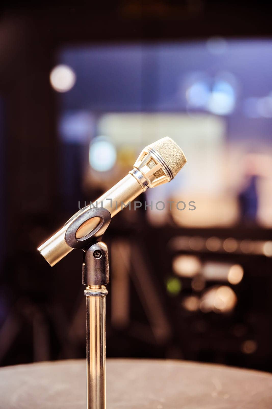 Metal microphone in the studio, studio lights in the blurry background