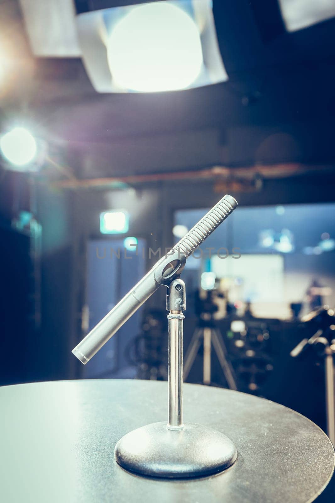 Metal microphone in the studio, studio lights in the blurry background