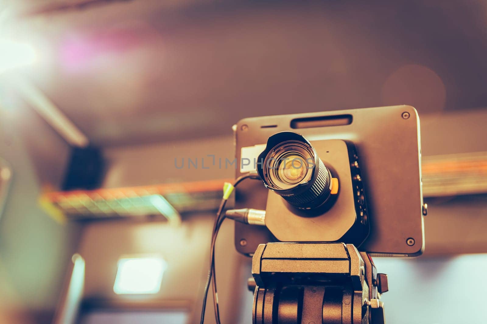 Film camera on a tripod in a television broadcasting studio, spotlights and equipment