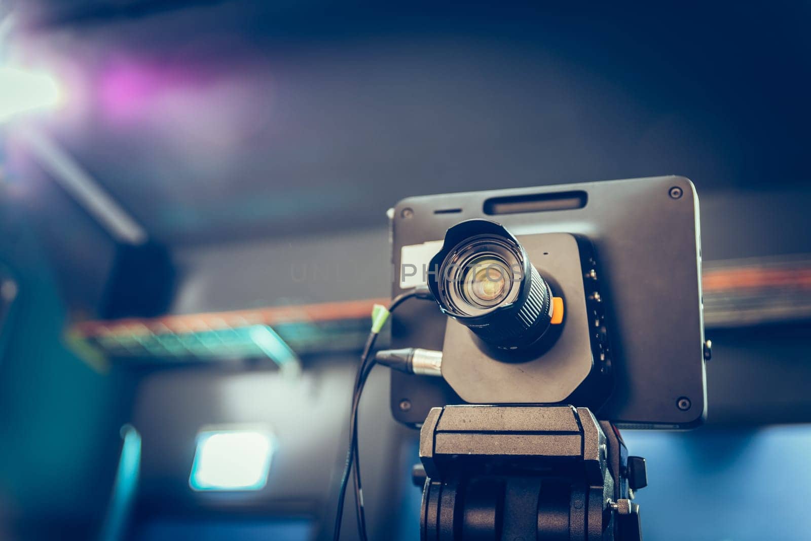 Film camera on a tripod in a television broadcasting studio, spotlights and equipment