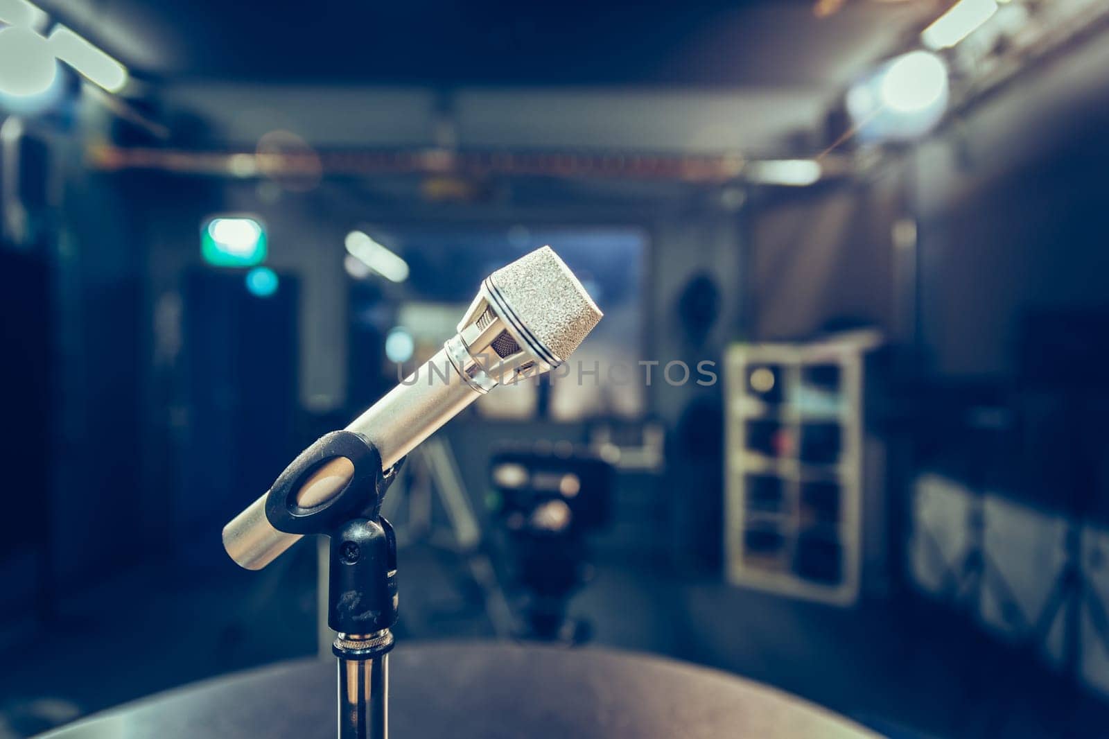 Metal microphone in the studio, studio lights in the blurry background