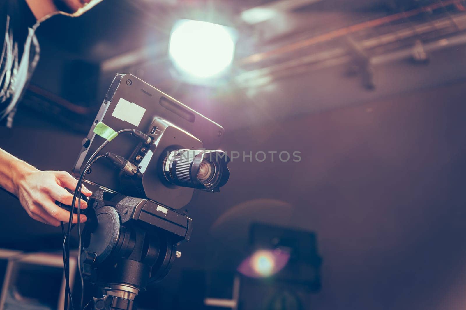 Male cameraman is operating a film camera in a television studio