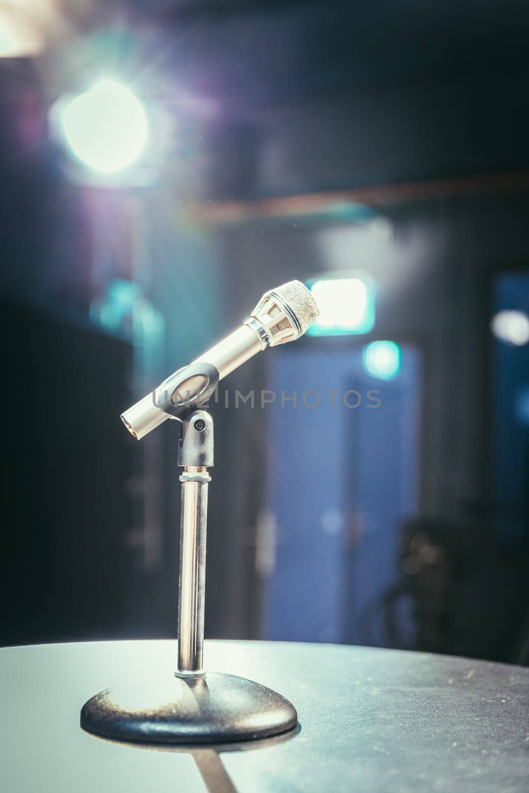 Metal microphone in the studio, studio lights in the blurry background
