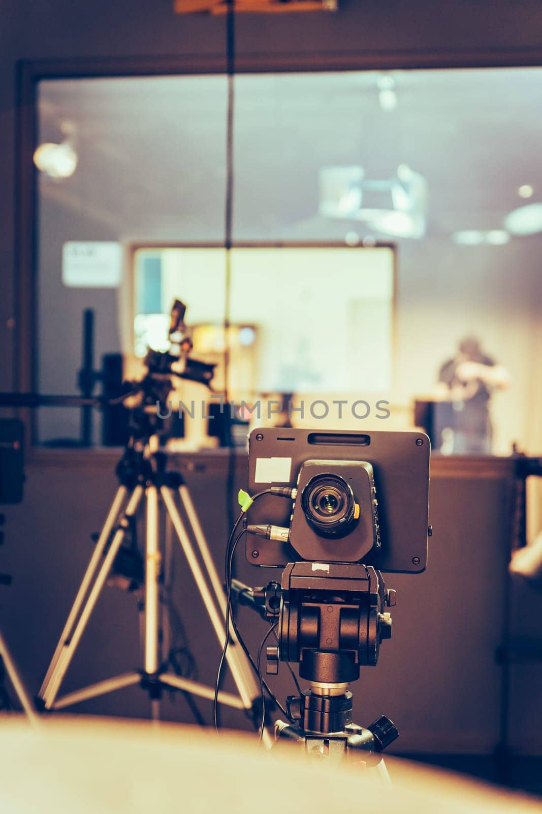 Film camera on a tripod in a television broadcasting studio, spotlights and equipment