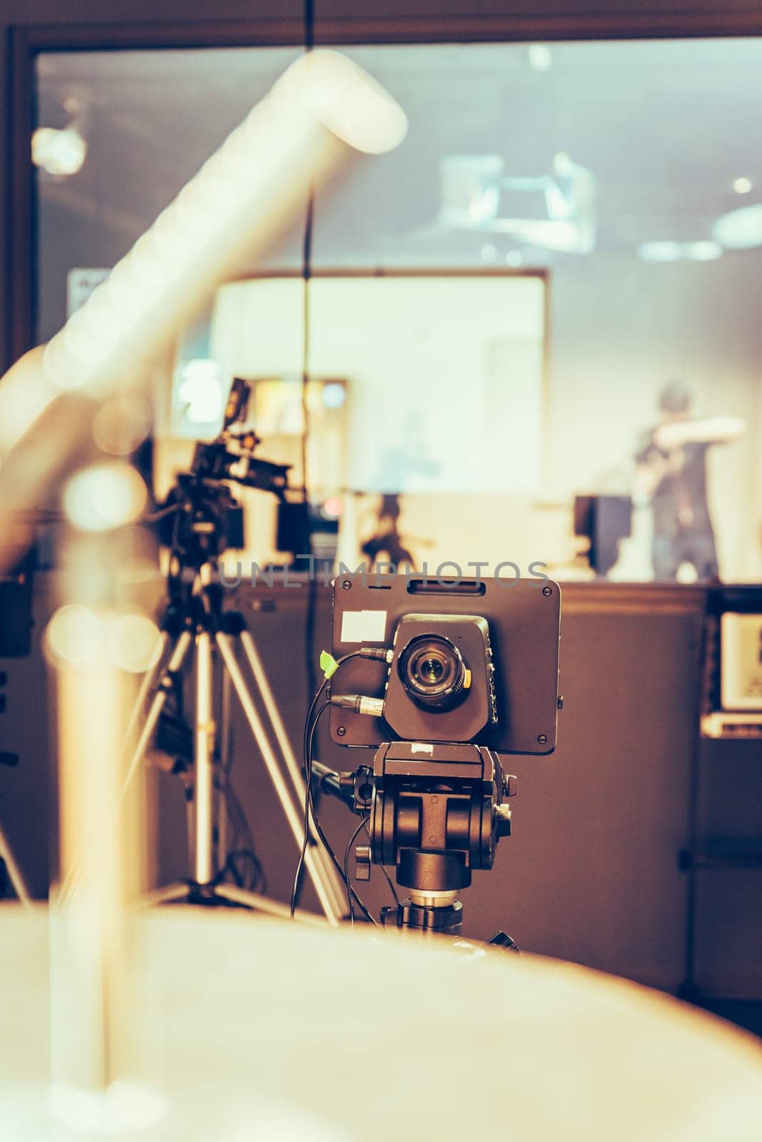Film camera on a tripod in a television broadcasting studio, spotlights and equipment