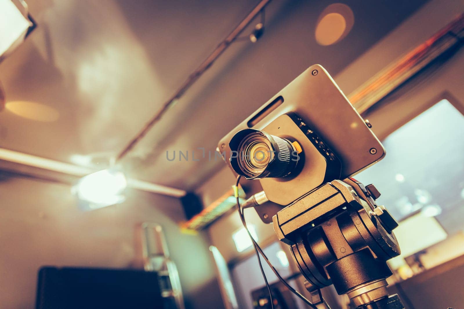 Film camera on a tripod in a television broadcasting studio, spotlights and equipment