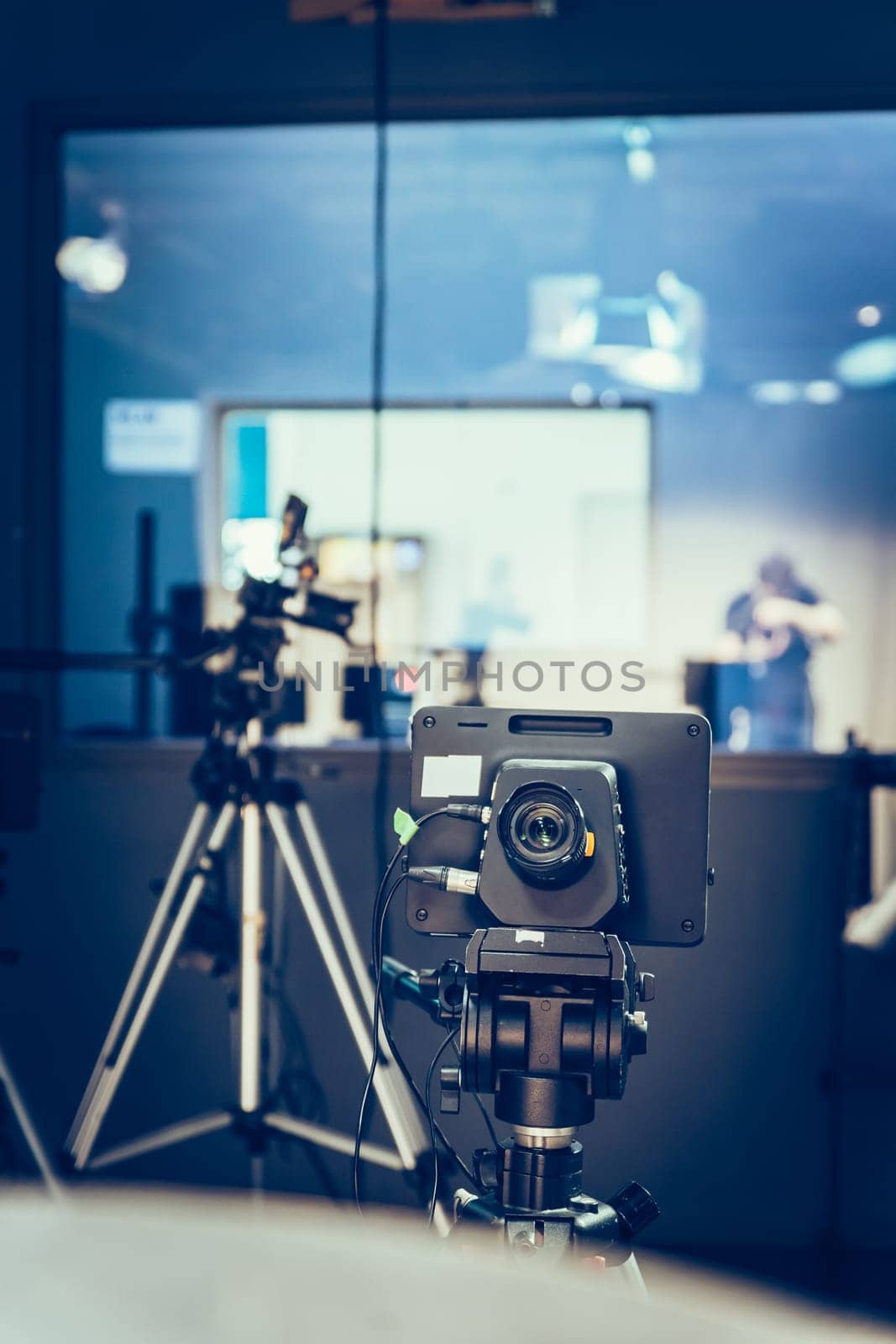 Film camera on a tripod in a television broadcasting studio, spotlights and equipment