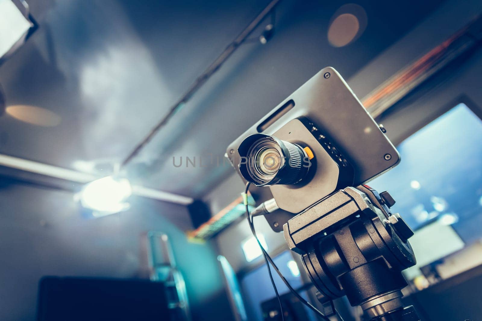 Film camera on a tripod in a television broadcasting studio, spotlights and equipment