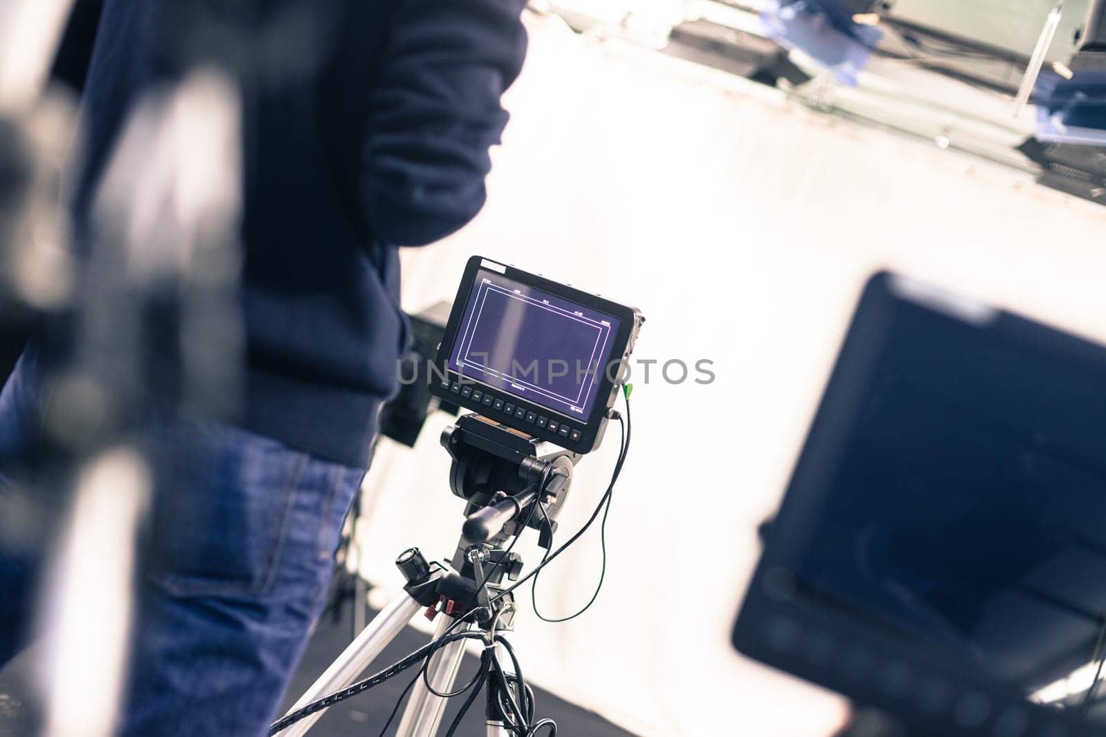 Male cameraman is operating a film camera in a television studio