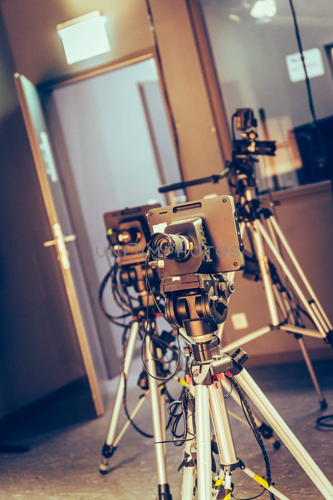 Film camera on a tripod in a television broadcasting studio, spotlights and equipment
