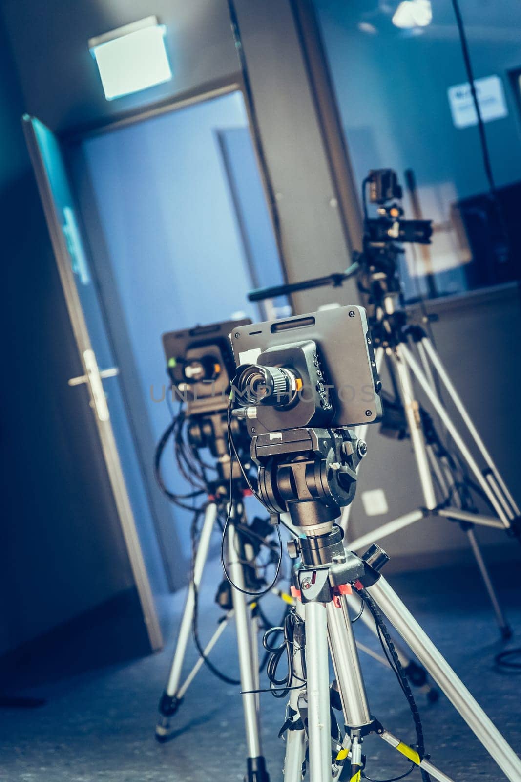 Film camera on a tripod in a television broadcasting studio, spotlights and equipment