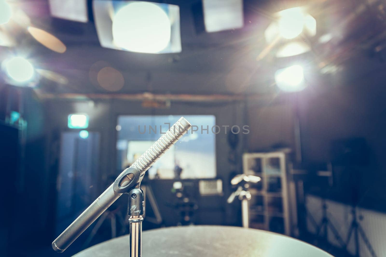 Metal microphone in the studio, studio lights in the blurry background