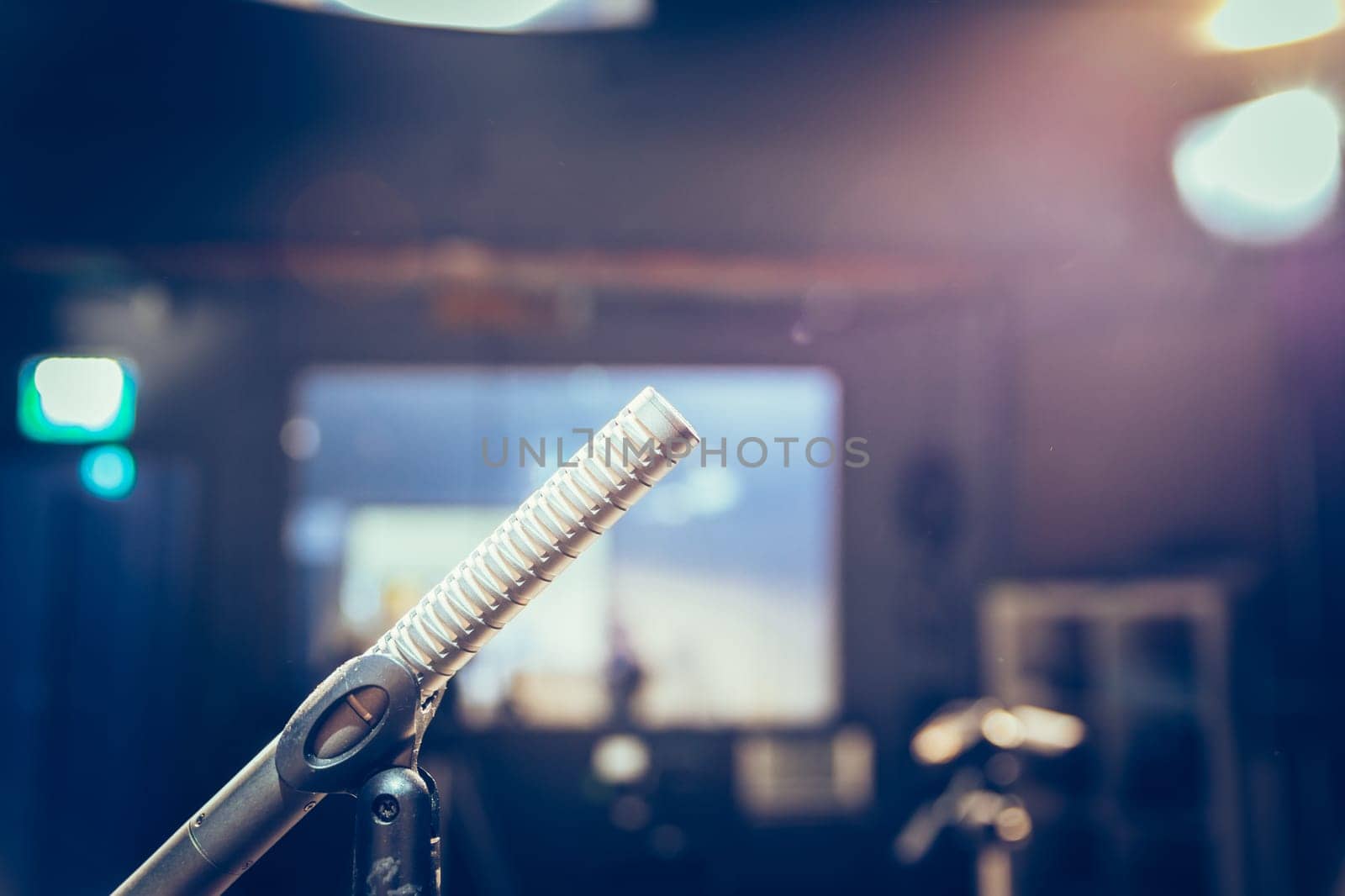 Metal microphone in the studio, studio lights in the blurry background