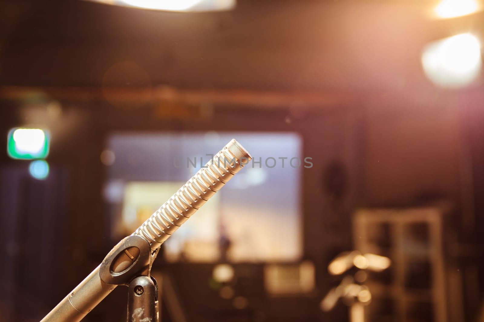 Metal microphone in the studio, studio lights in the blurry background
