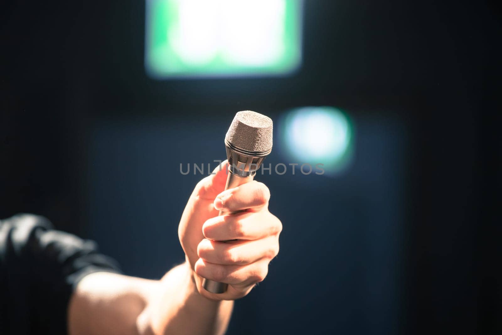 Person is holding up a metal microphone and wants to interview someone, copy space