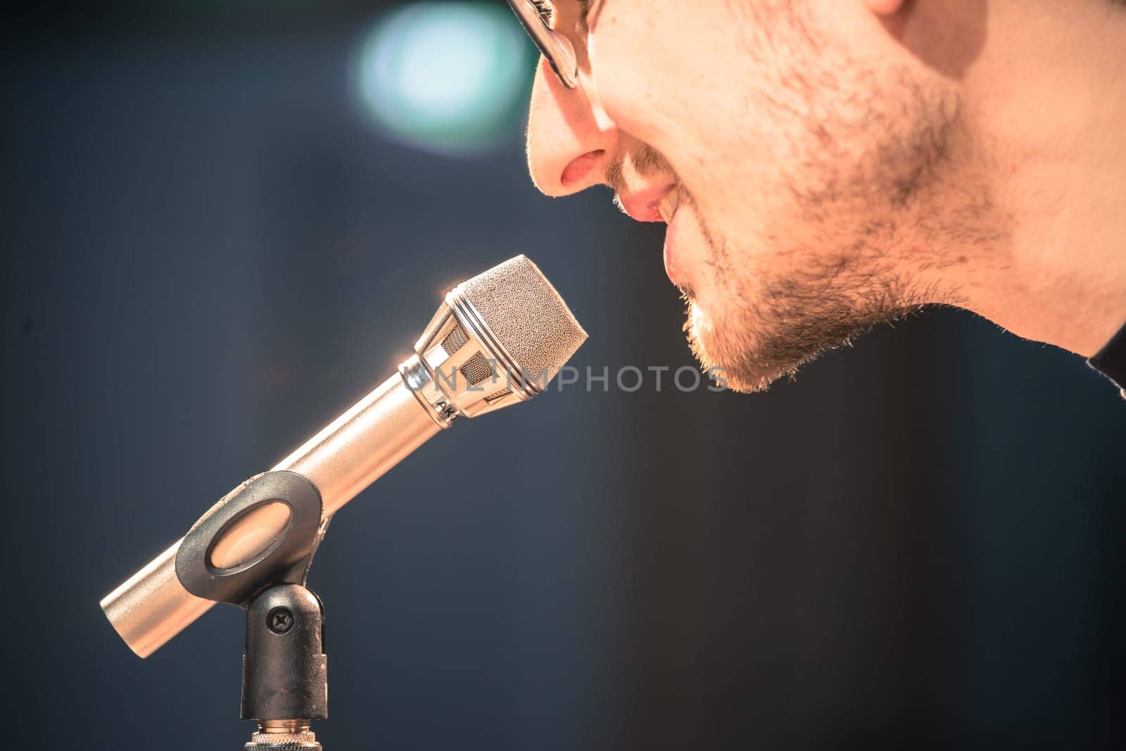 Young man on the stage is talking into a microphone, speech