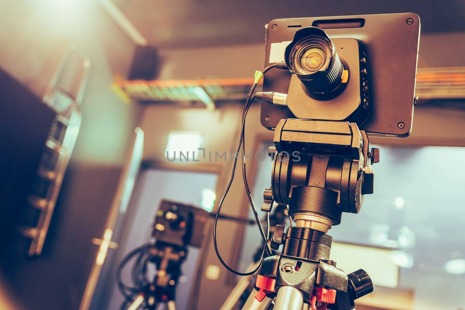 Film camera on a tripod in a television broadcasting studio, spotlights and equipment
