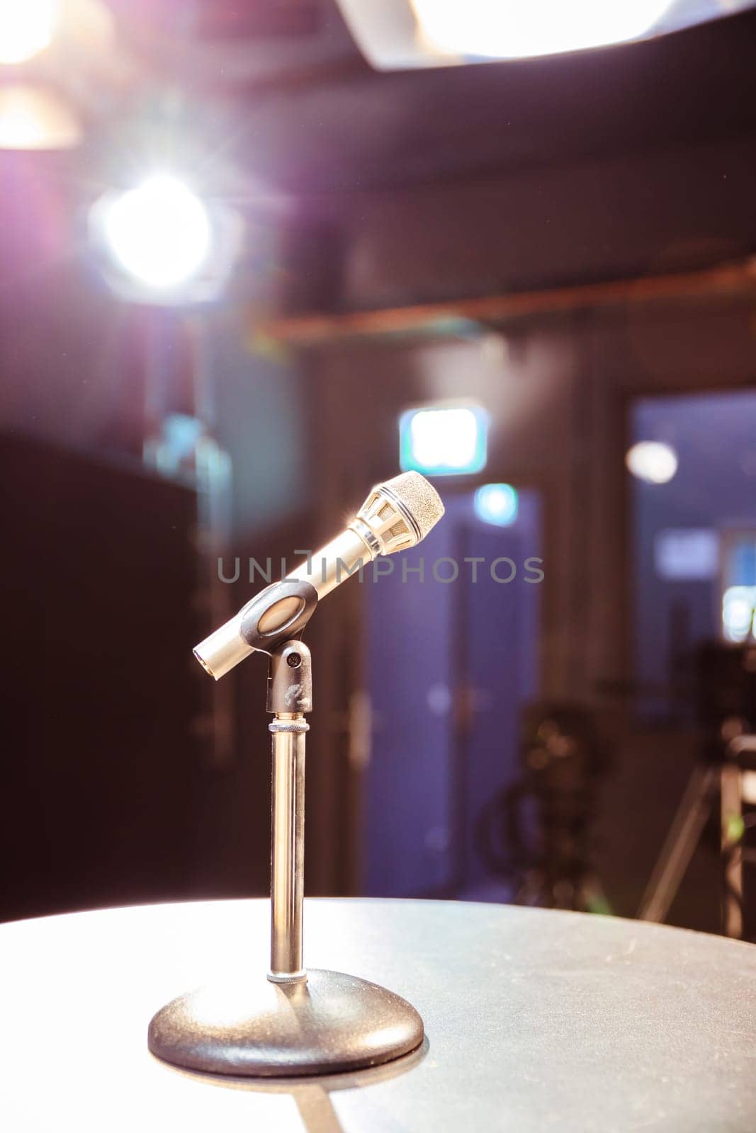 Metal microphone in the studio, studio lights in the blurry background