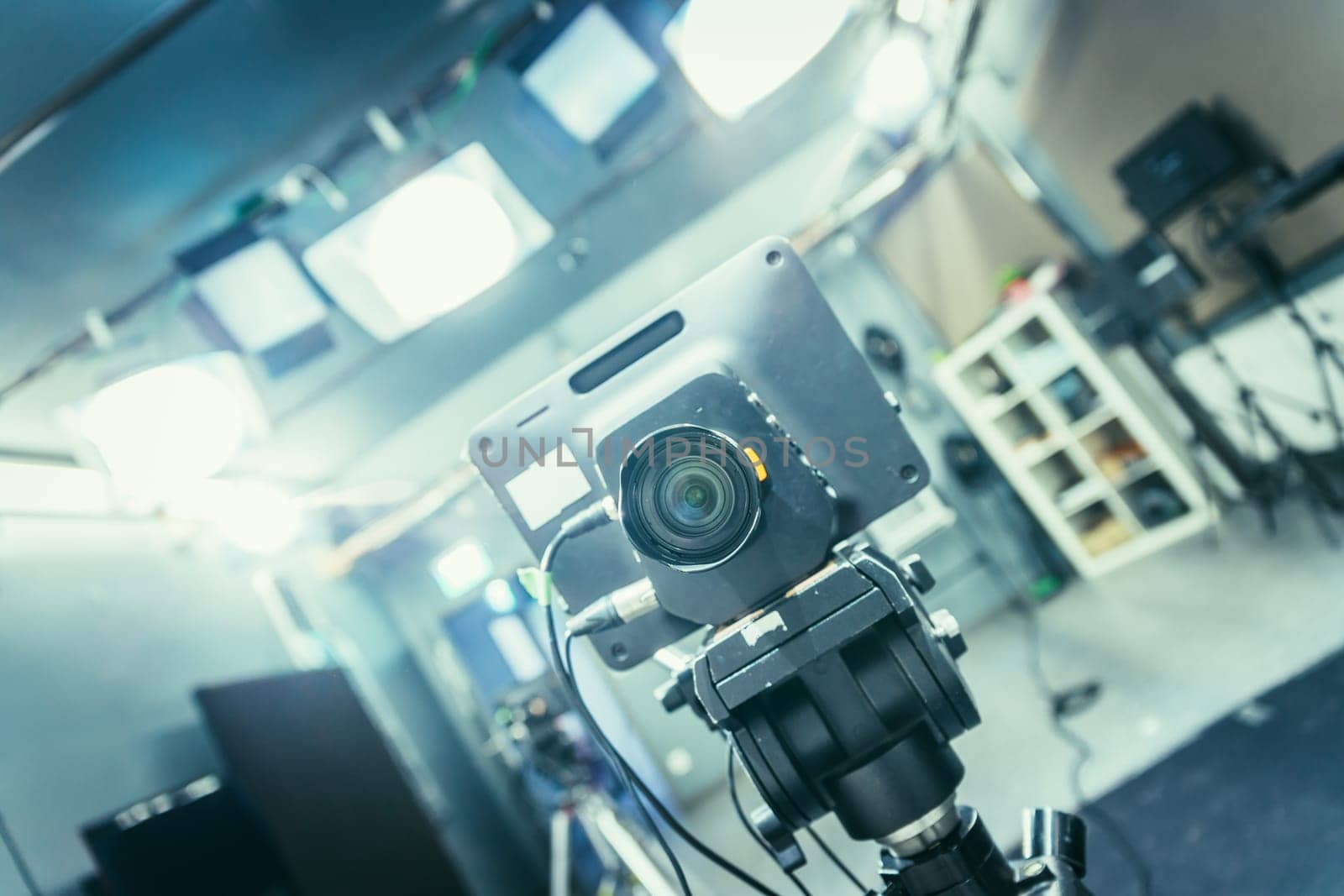 Lens of a film camera in an television broadcasting studio, spotlights and equipment