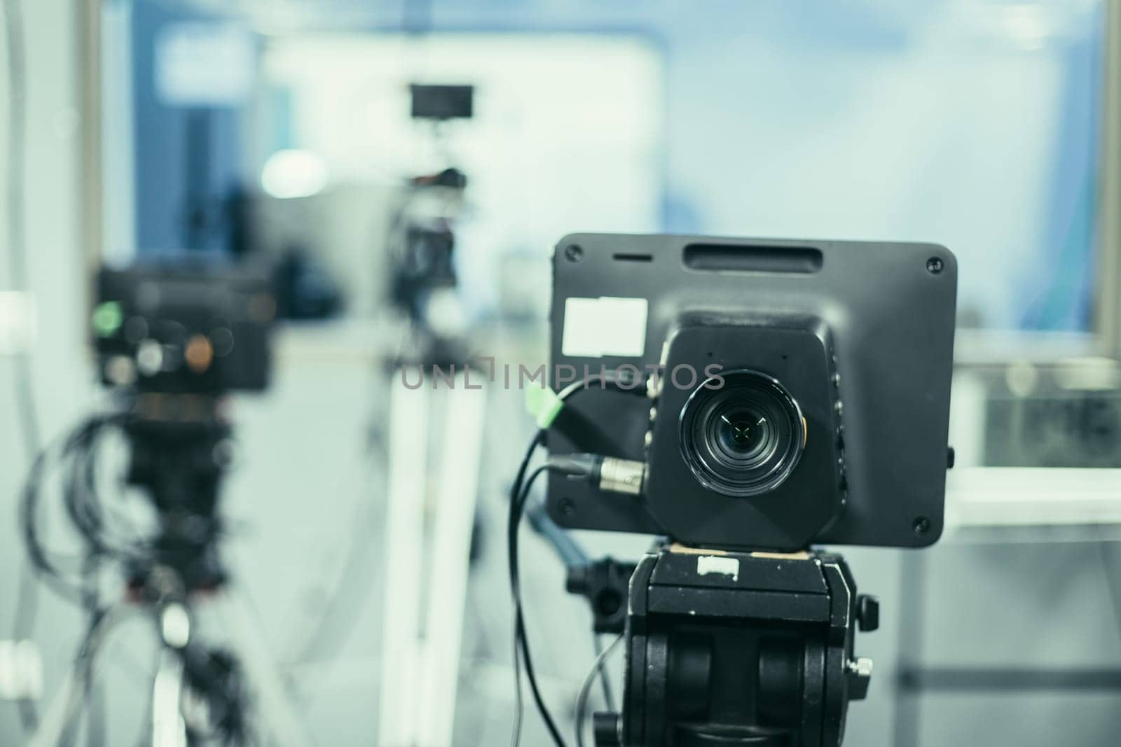 Lens of a film camera in an television broadcasting studio, spotlights and equipment