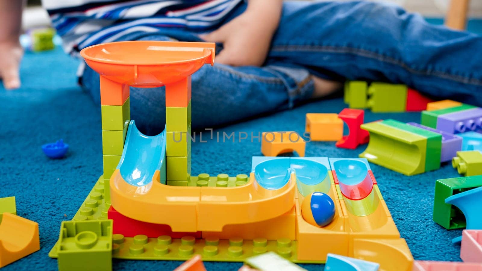 Closeup image of colorful track for marble run in playroom.