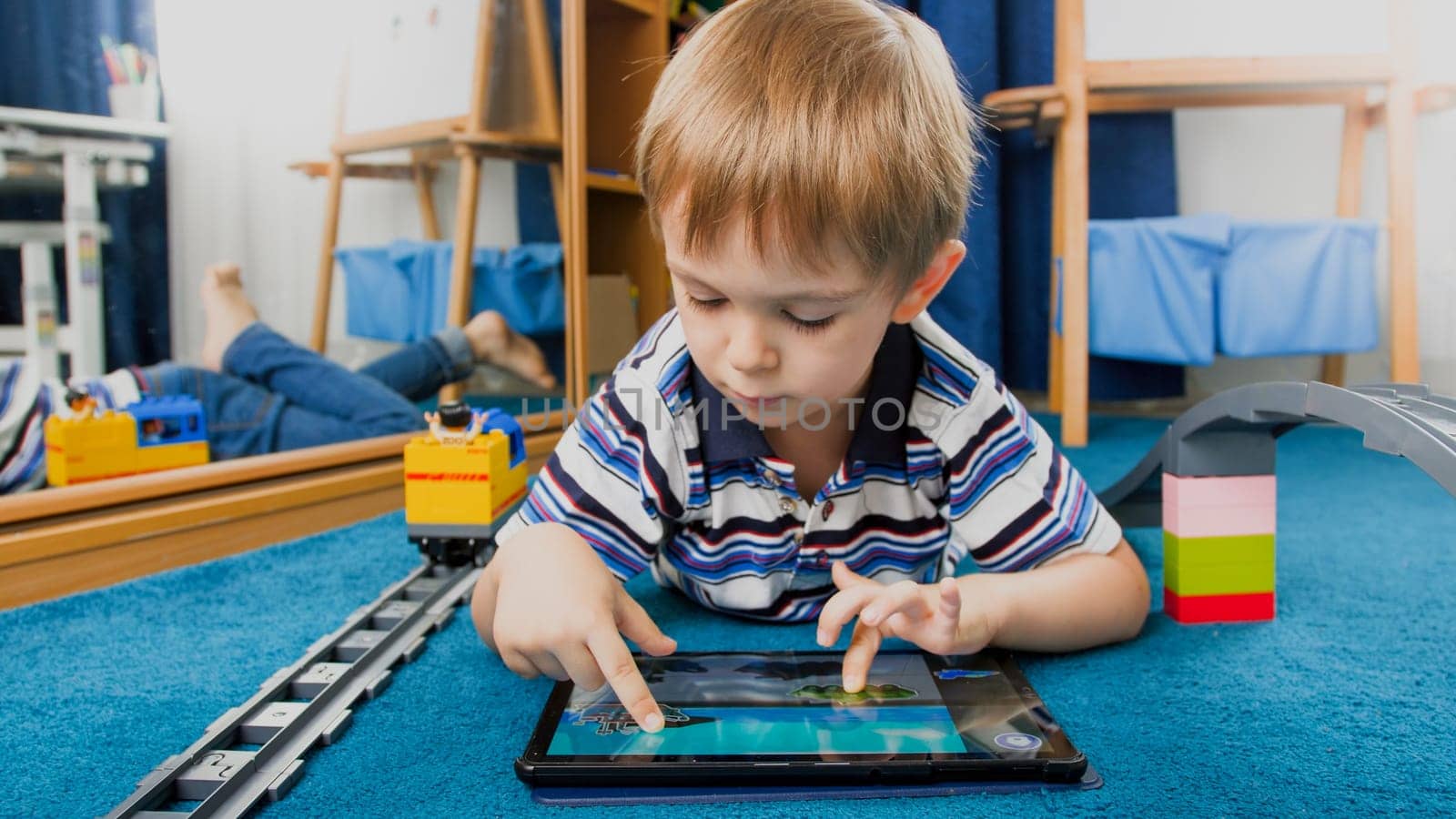 Portrait of smiling boy using pad computer for playing games.