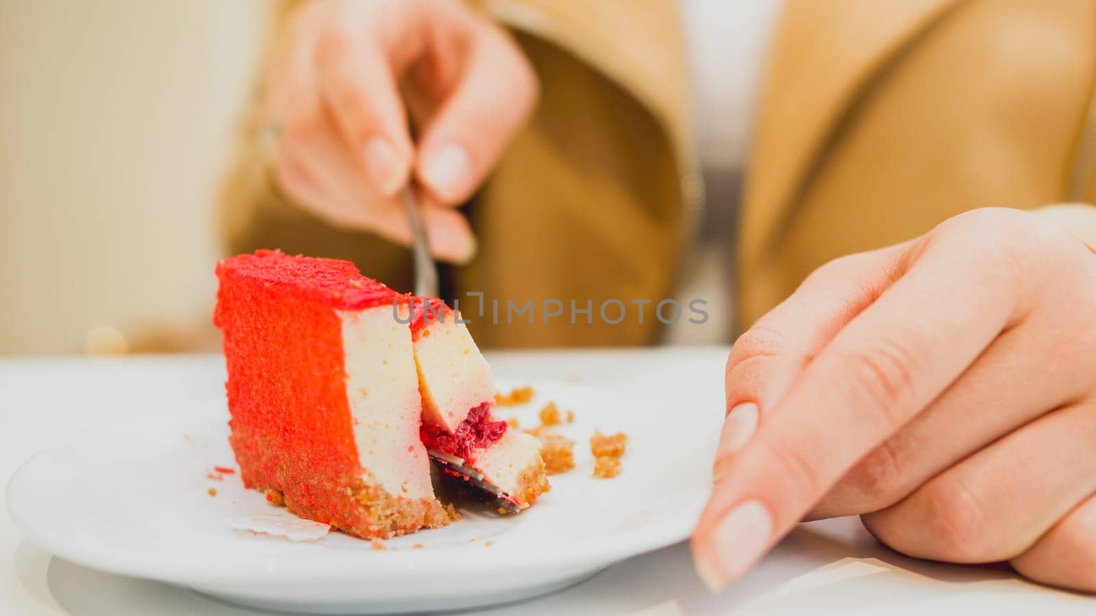 Toned photo of young woman eating sweet cake in cafe.