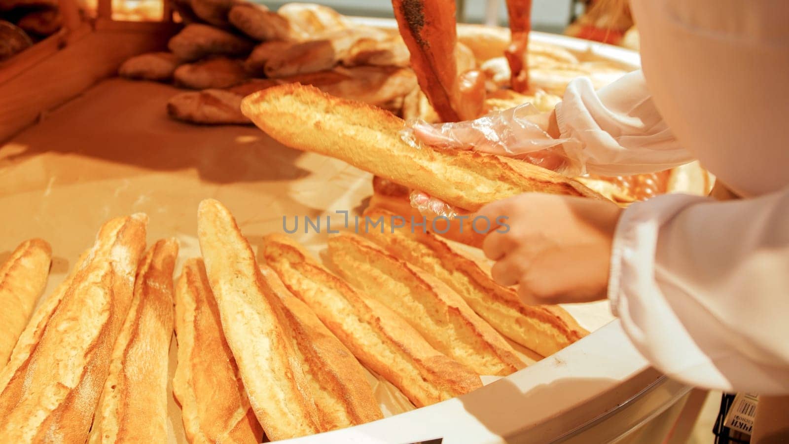 Closeup photo of female hands takingfresh baked bread in grocery store.