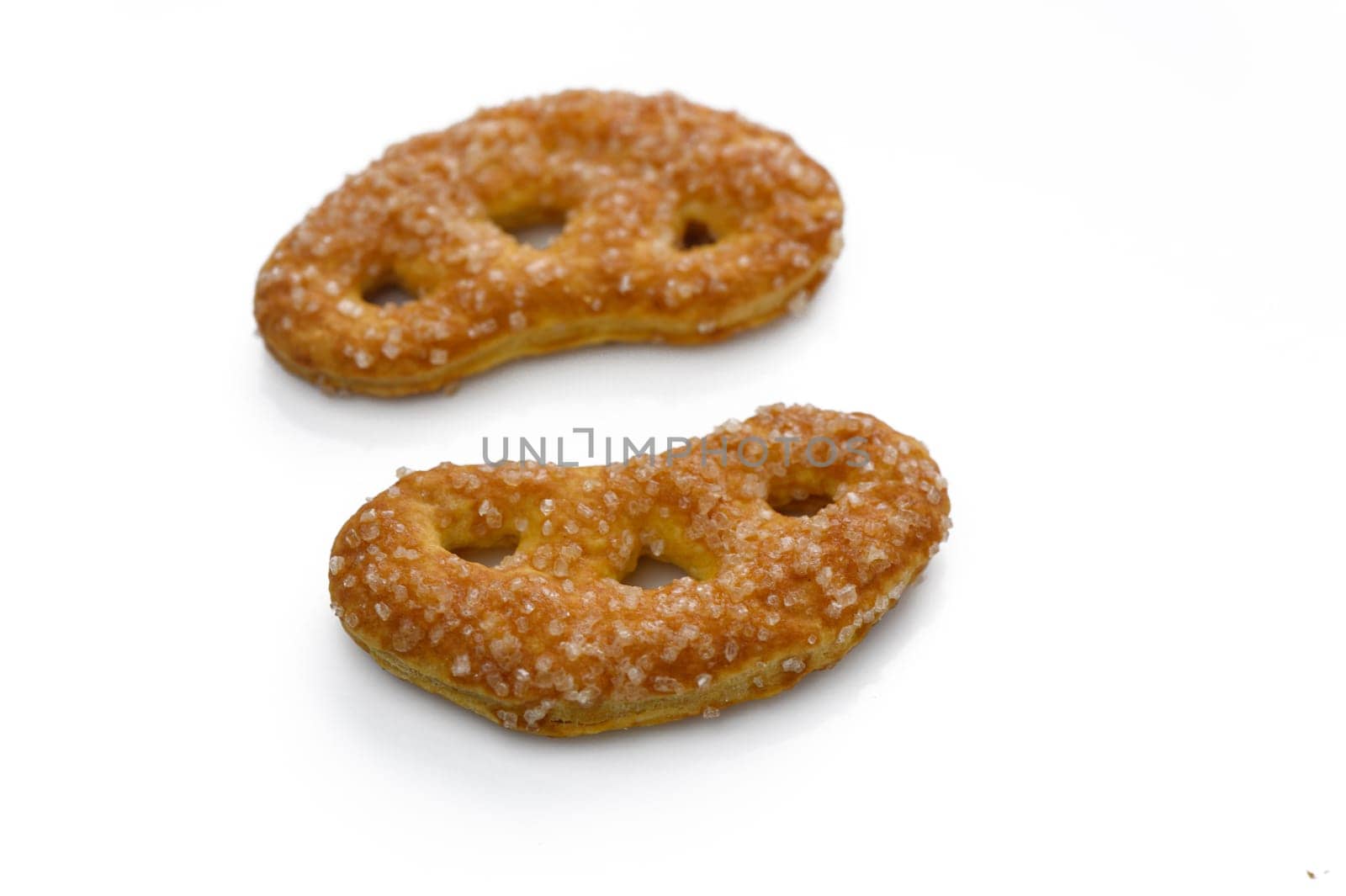Delightful sugar-coated pretzels resting on a smooth surface, inviting taste buds with their unique shape.
