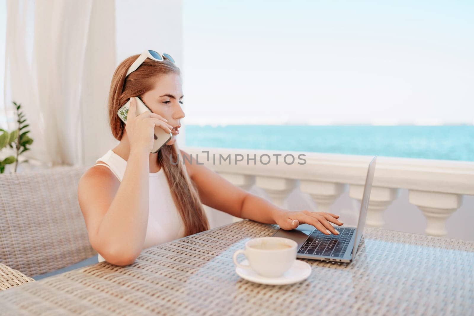 Woman coffee cafe macbook. Woman sitting at a coffee shop with mobile phone drinking coffee and looking away. Caucasian female relaxing at a cafe
