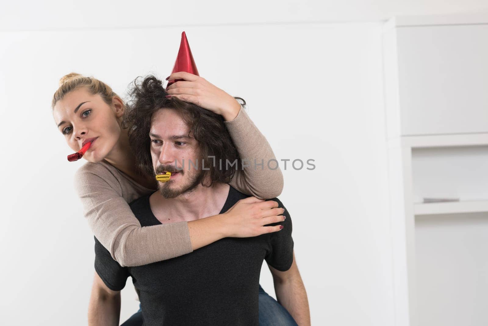 happy young romantic  couple in love  celebrating and blowing confetti decorations at new year and charismas  party