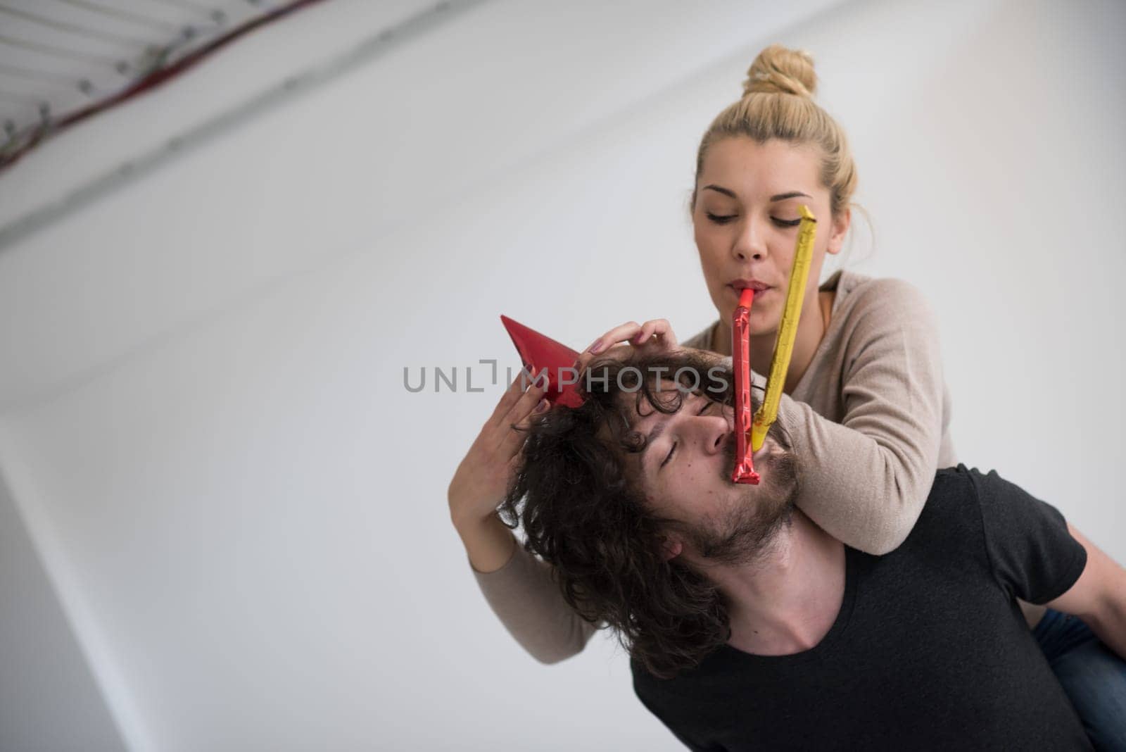 happy young romantic  couple in love  celebrating and blowing confetti decorations at new year and charismas  party