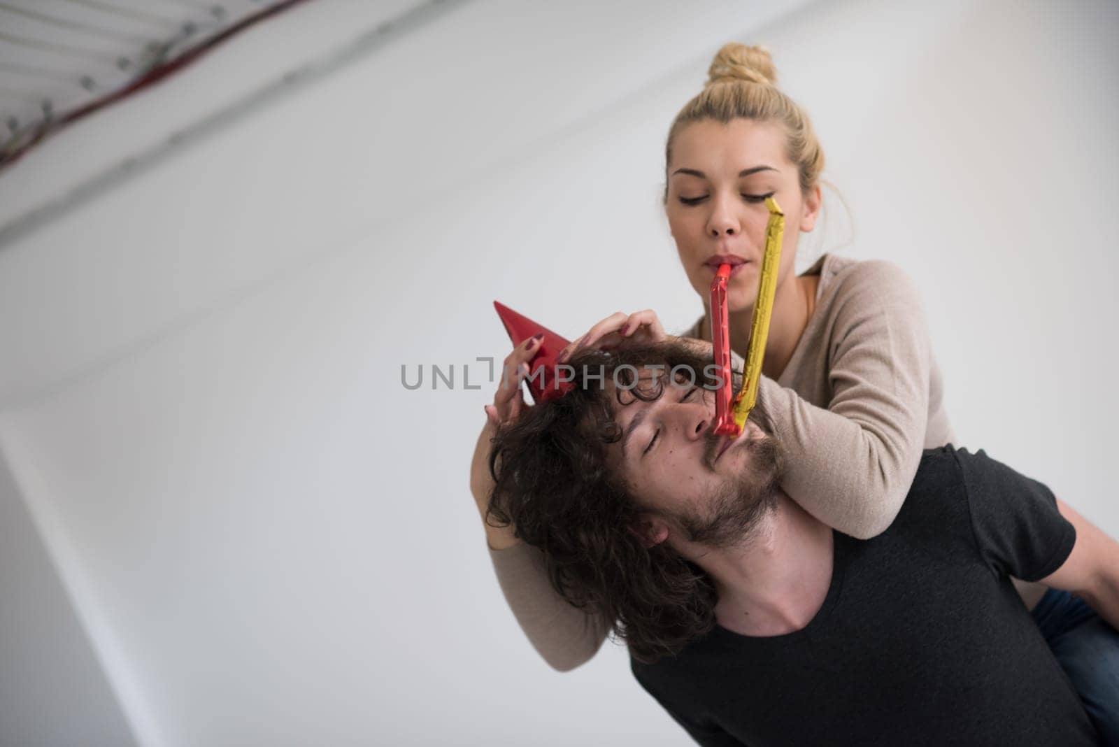 happy young romantic  couple in love  celebrating and blowing confetti decorations at new year and charismas  party