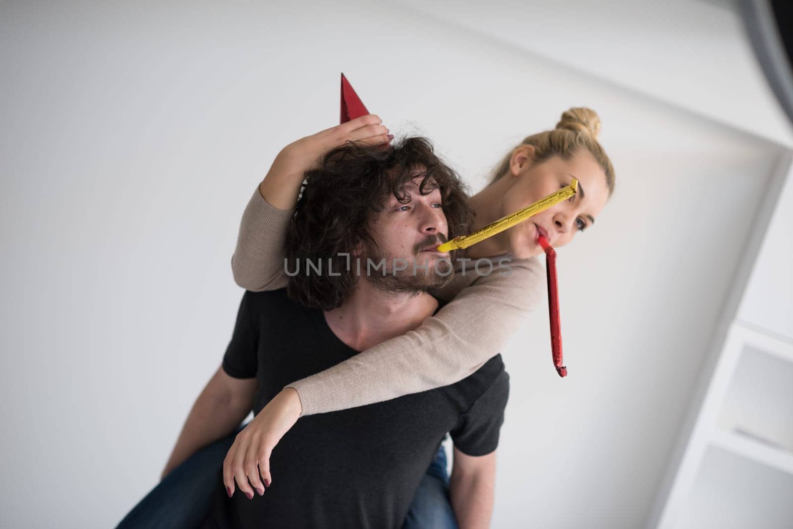 happy young romantic  couple in love  celebrating and blowing confetti decorations at new year and charismas  party