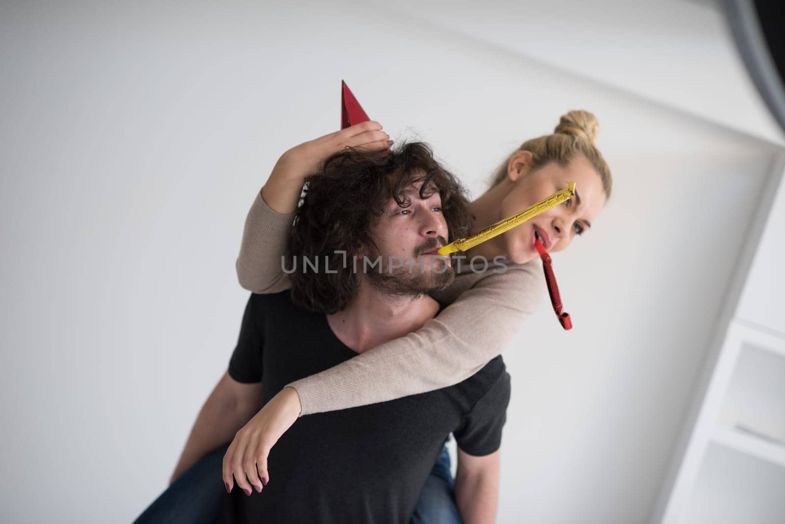 happy young romantic  couple in love  celebrating and blowing confetti decorations at new year and charismas  party