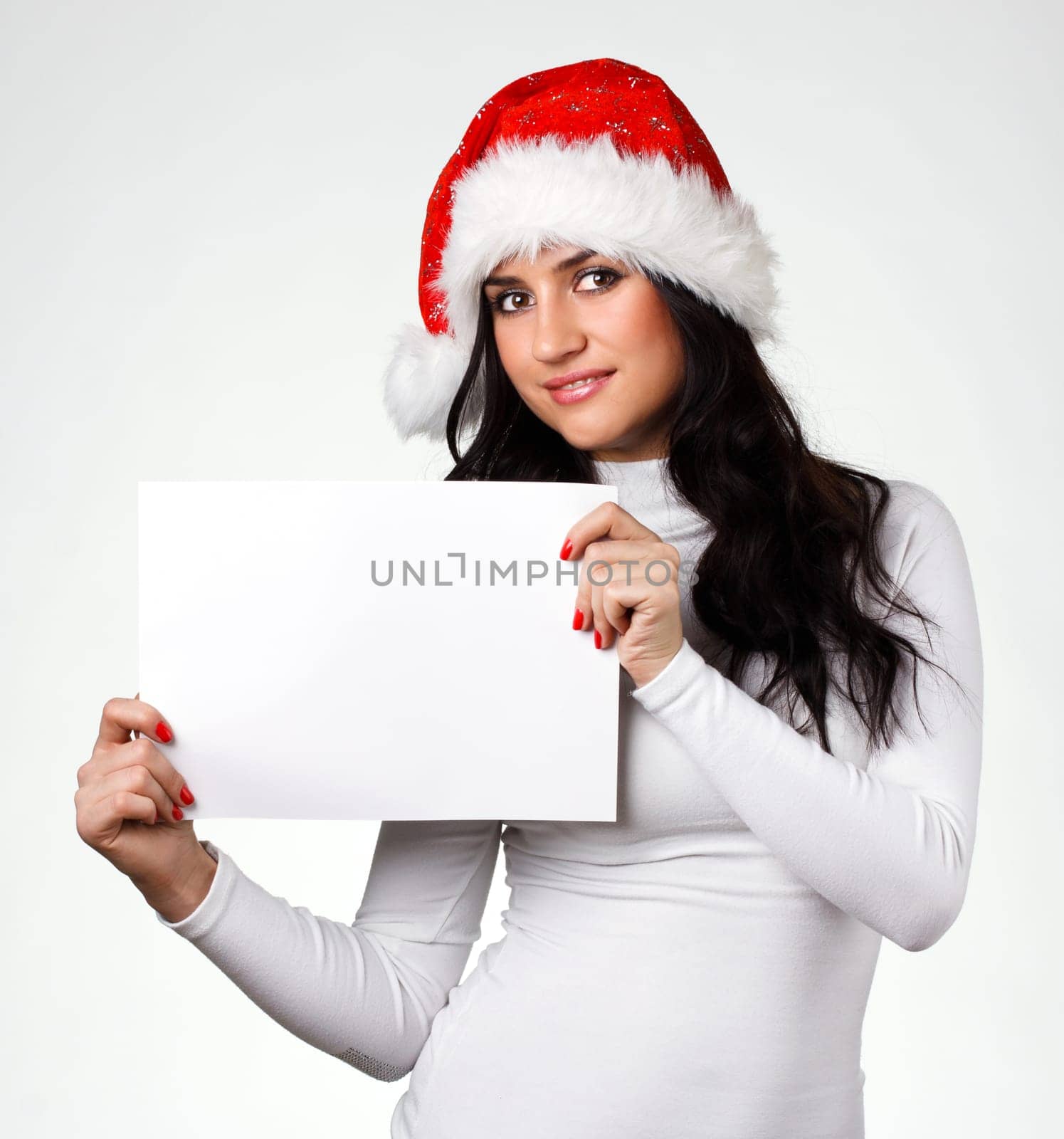 beautiful girl in a Santa Claus hat with a clean sheet of paper on a white background