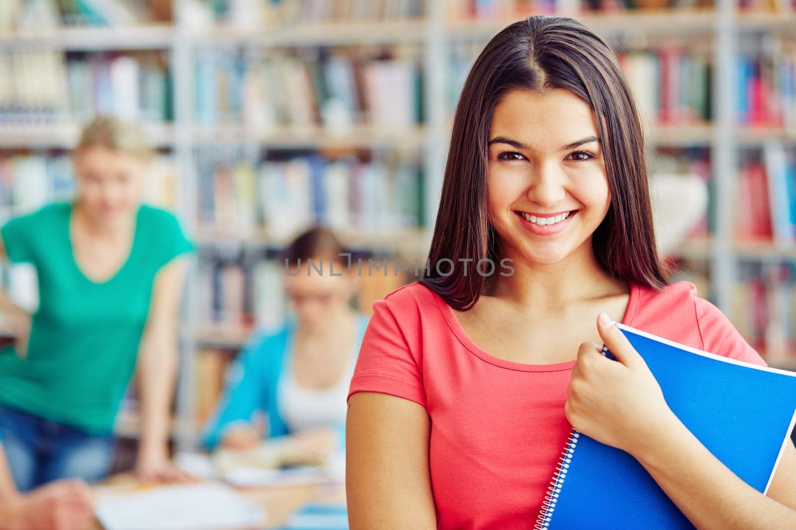 Smiling teenager with copybook looking at camera
